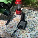 Weboost amplifier connected to antenna on picnic table at campsite.