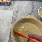 Paint the bottom pie dough with egg wash to prevent soggy pie crust for the chicken pot pie.