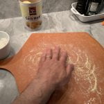 Cornmeal added to flour mix for dusting work surface and bottom of pizza dough to help prevent sticking.