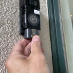 With the lock tab depressed, remove the battery from the Ring doorbell body.