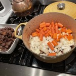 Saute coarsely chopped onion, carrots and minced garlic to the heavy pot the beef was browned in.