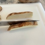 Cut Russet potatoes lengthwise into 3/8" - 1/2" thick slices using a large chefs knife.