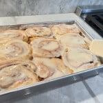 After baking cinnamon rolls, apply icing to the rolls while they are still warm.