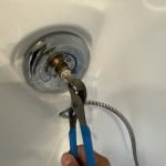 Remove faucet cartridge by pulling on stem with adjustable wrench or specialized puller tool.