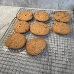 Homemade chocolate chip cookies cooling on a cooling rack.